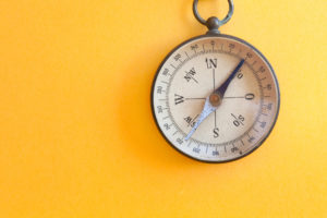 Vintage compass on a yellow background 