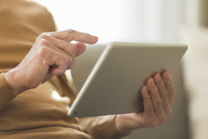 Elderly person holding a tablet 